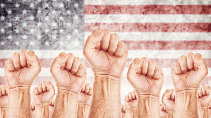 raised fists in front of American flag