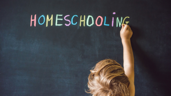 child writes homeschooling on chalkboard