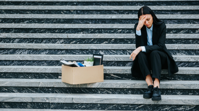 woman fired or laid off sitting on steps
