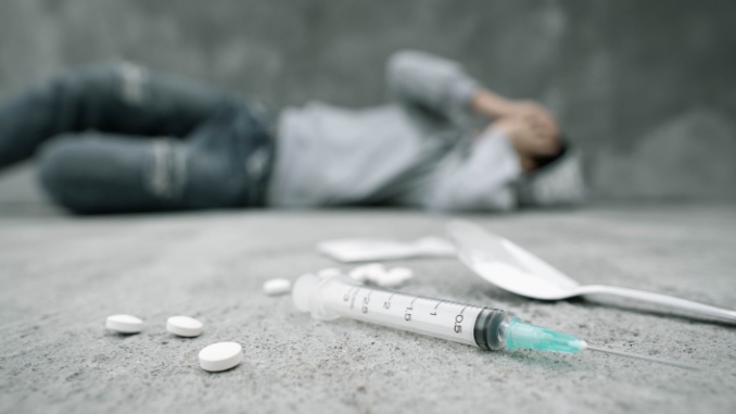 person lying on ground after abusing drugs